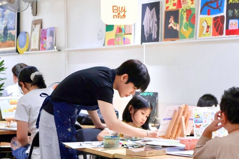 Giáo viên hướng dẫn bé vẽ thiếu nhi tại lớp Bụi Nhỏ
